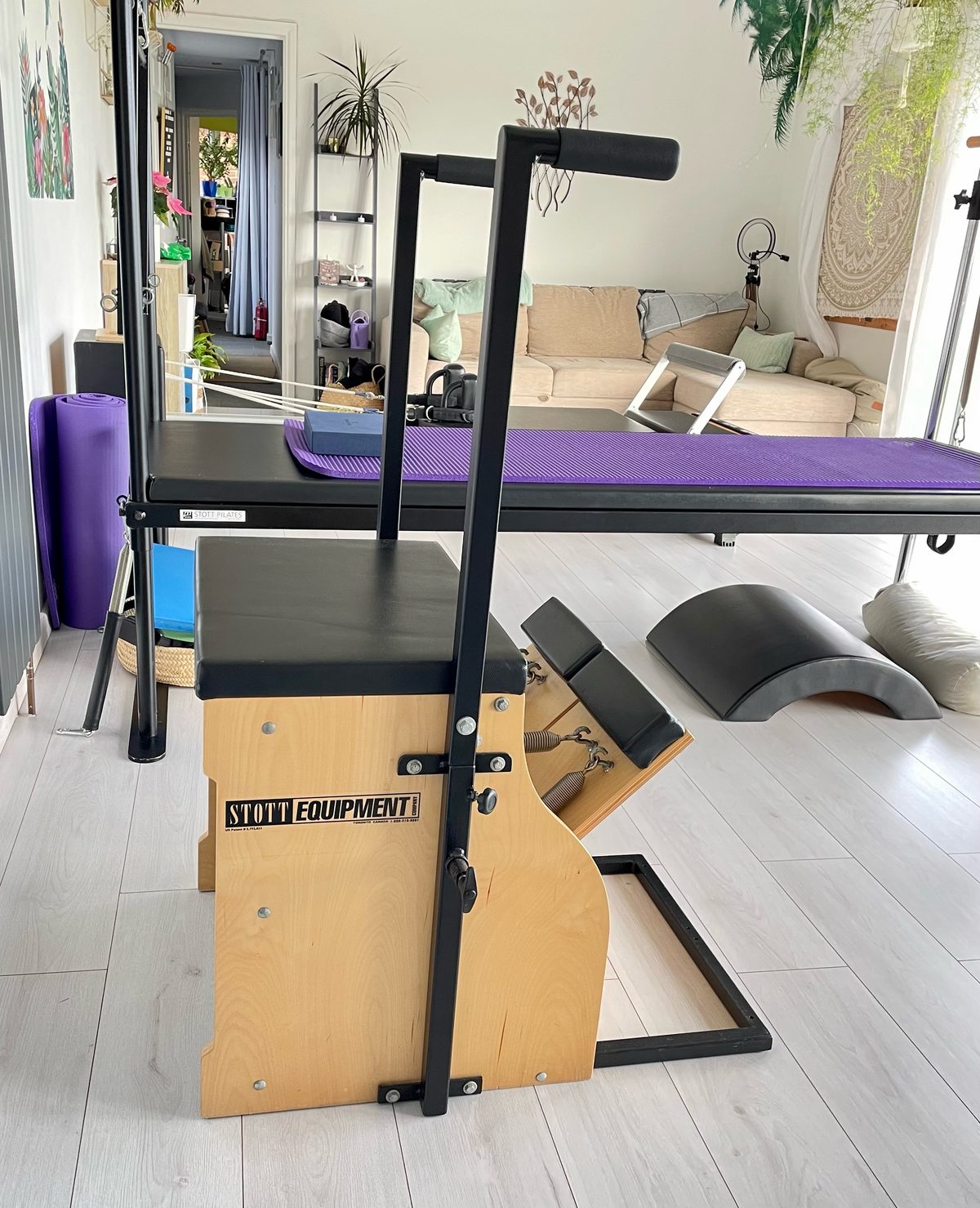 The STOTT Pilates chair in the studio, with the reformer and mirrors behind.